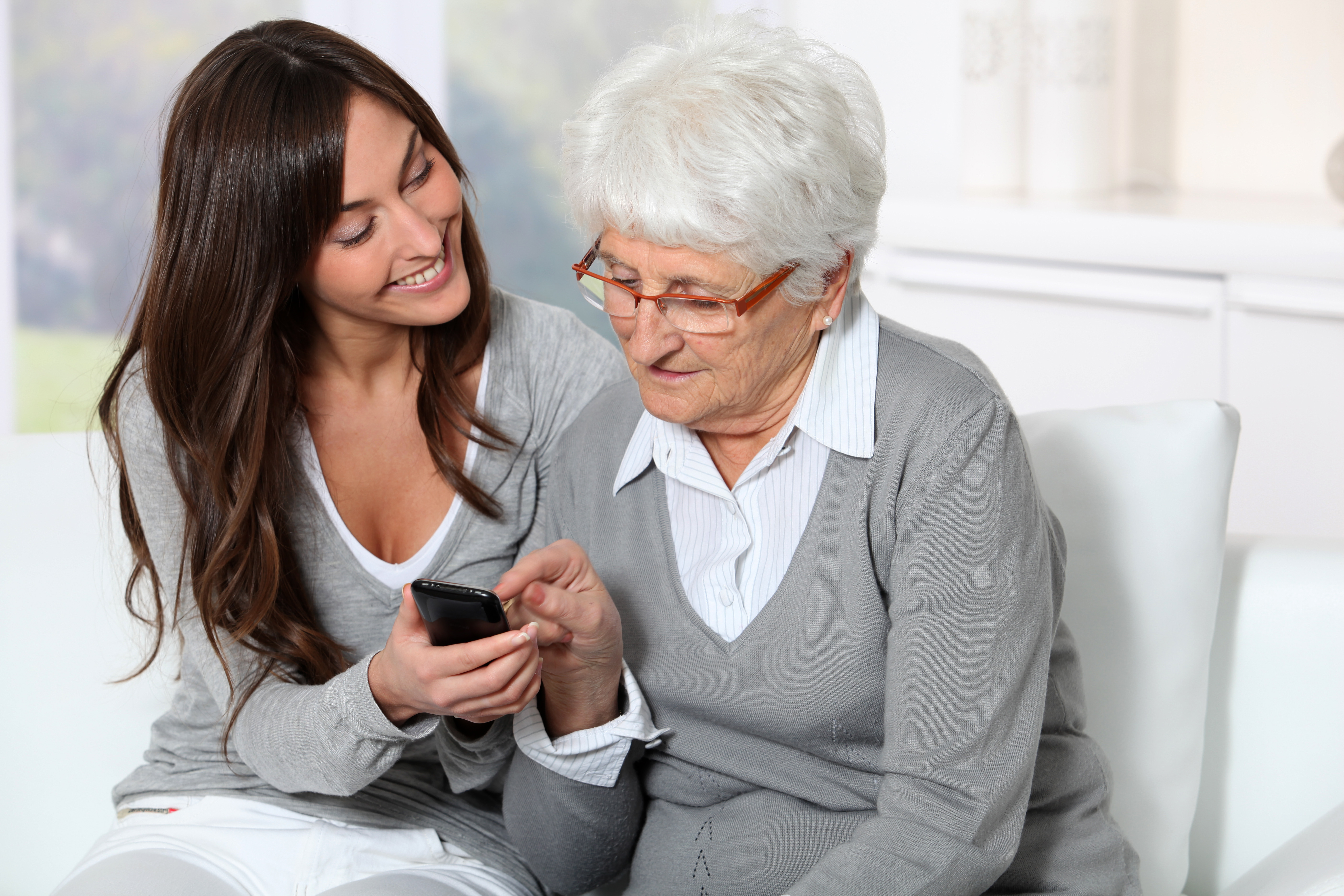 An elderly woman utilizing a cell phone to make a call.